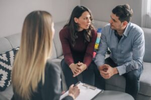 A couple speaking with a counselor during a session about addiction support and recovery
